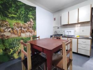 una cocina con mesa y sillas y una pintura de tigres en Casa Uziel en Humahuaca