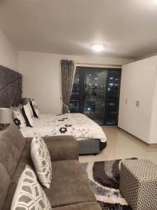a bedroom with a bed and a couch at Umhlanga flat near Gateway mall in Durban +8 photos
