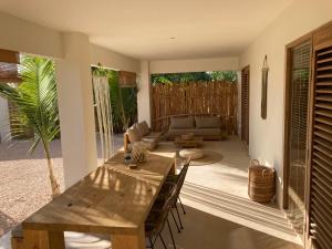 uma sala de estar com uma mesa de madeira e cadeiras em Isla penthouse & garden apartments Bonaire em Kralendijk