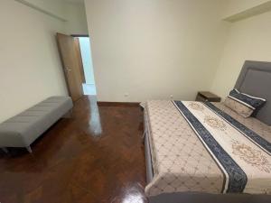 ein Schlafzimmer mit 2 Betten und einer Bank darin in der Unterkunft Pimenova Residence in Luanda