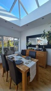 a dining room with a table with chairs and a ceiling at House on Costal Village in Peacehaven