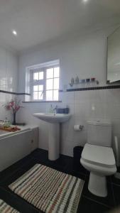 a bathroom with a white toilet and a sink at House on Costal Village in Peacehaven