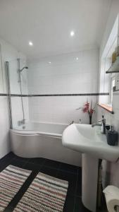a bathroom with a tub and a sink and a bath tub at House on Costal Village in Peacehaven