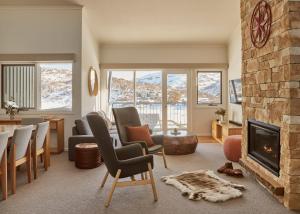 a living room with a fireplace and a table and chairs at Lodge Apartment 21 The Stables Perisher in Perisher Valley