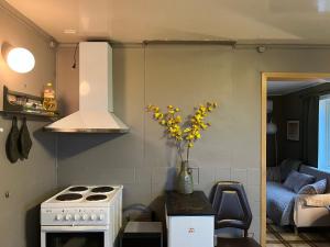 eine Küche mit einem Herd und einer Vase mit gelben Blumen in der Unterkunft Hos Laura & Valdemar in Nord-Lenangen