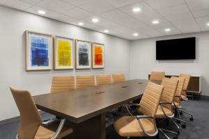 uma sala de conferências com uma grande mesa de madeira e cadeiras em Holiday Inn Express Atlanta Airport - North, an IHG Hotel em Atlanta