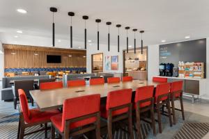 a dining room with a large table and red chairs at Holiday Inn Express Atlanta Airport - North, an IHG Hotel in Atlanta