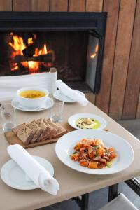 a table with plates of food in front of a fireplace at Sole East Resort in Montauk