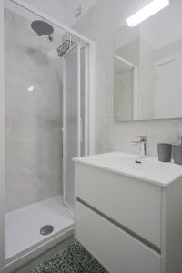 ein weißes Bad mit einer Dusche und einem Waschbecken in der Unterkunft Al Castello Avezzano in Avezzano