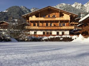 duży drewniany budynek z śniegiem przed nim w obiekcie Wellnessappartements Margit w Alpbach