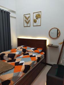 a bedroom with a bed with a colorful quilt at Family Villa Syariah C-33 with minipool in Batu