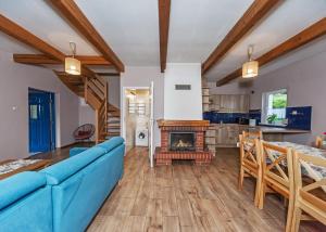 a living room with a blue couch and a fireplace at Domek na Hrobaczej in Międzybrodzie Bialskie