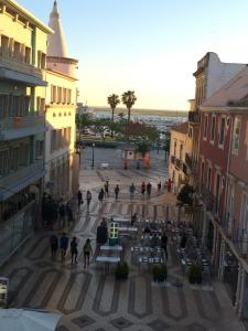 um grupo de pessoas andando em torno de uma praça em uma cidade em Aqua Ria Boutique Hotel em Faro