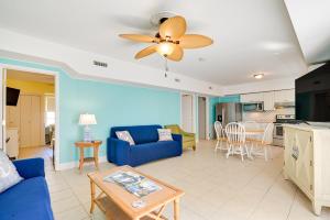 a living room with a blue couch and a table at Pawleys Island Retreat - Golf Cart Included! in Pawleys Island