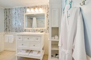 a white bathroom with a sink and a mirror at Pawleys Island Retreat - Golf Cart Included! in Pawleys Island +24 photos