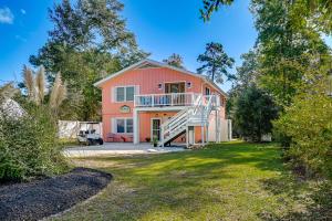 a large orange house with a staircase in the yard at Pawleys Island Retreat - Golf Cart Included! in Pawleys Island
