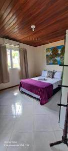a bedroom with a bed with a purple blanket at Vista Verde in Morro de São Paulo