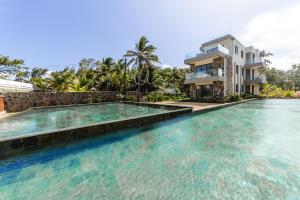 a swimming pool in front of a villa at Ocean Terraces Apt A1 - Your Beachfront Bliss - Brand NEW in Poste Lafayette