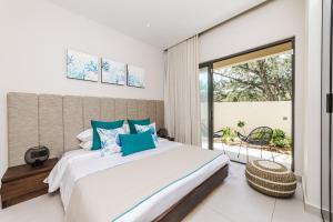 a bedroom with a large bed and a balcony at Ocean Terraces Apt A1 - Your Beachfront Bliss - Brand NEW in Poste Lafayette