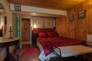 - une chambre avec un grand lit rouge dans l'établissement Chalet La Voraz, à Châtel