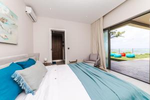 um quarto com uma cama e uma grande janela em Ocean Terraces Apt A1 - Your Beachfront Bliss - Brand NEW em Poste Lafayette