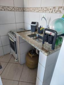 Il comprend une petite cuisine équipée d'un évier et d'une cuisinière. dans l'établissement Linda kitinet, à Cabo Frio