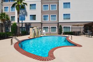 a swimming pool in front of a building at Residence Inn Beaumont in Beaumont