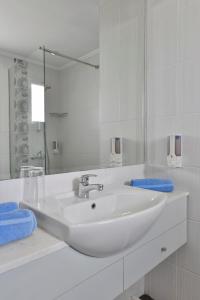 a white bathroom with a sink and a mirror at Napa Prince Hotel Apts in Ayia Napa