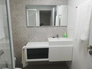 Marea apartamento. في آدرا: حمام مع حوض أبيض ومرآة