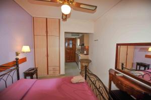 科孚镇Angela Corfu的卧室里有一张床，上面铺着粉色毯子 更多53张照片