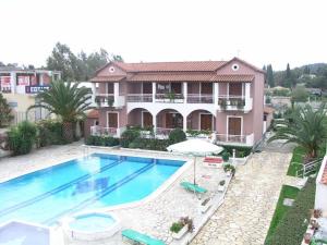 a villa with a swimming pool in front of a house at Angela Corfu in Corfu