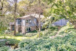 una casa en una colina con un estanque delante en Pet-Friendly Pennsylvania Abode - Deck and Fireplace, en Gibsonia