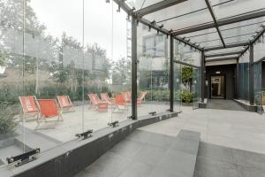 szklany dom z pomarańczowymi krzesłami na patio w obiekcie Warsaw City Apartments Stadion Narodowy w Warszawie