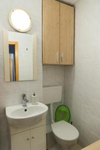 uma casa de banho com um lavatório, um WC e um espelho. em Lara's Residence em Timisoara