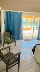 a room with two chairs and a bed and blue curtains at La Isla Bonita in Punta Rucia