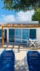 two chairs and a table on a house with windows at La Isla Bonita in Punta Rucia