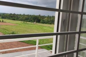une fenêtre avec vue sur un champ dans l'établissement Entire FF bunglow, garden, green surrounding, hall, à Mysore