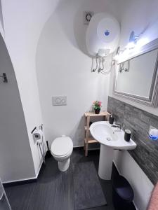 a bathroom with a white toilet and a sink at Casa Vacanza Ti Ospito io in Catania