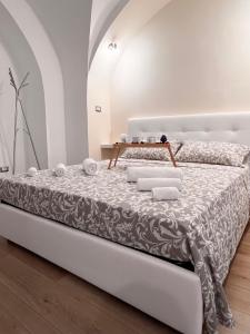 a white bed in a white room with towels on it at Casa Vacanza Ti Ospito io in Catania