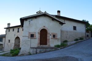 an old stone building with a door on a street at A Casa Di Mì Appartamenti vacanza in Montefalco