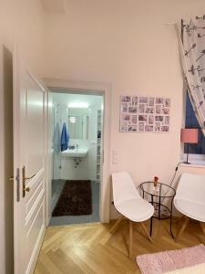 Cette chambre blanche dispose d'une table et d'une salle de bains. dans l'établissement Apartment St Stephens Cathedral, à Vienne