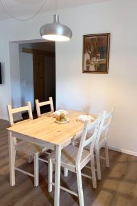 - une table à manger en bois avec des chaises et un éclairage dans l'établissement NOOK studio apartman Lokve, à Lokve