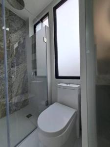 ein Bad mit einem WC, einer Dusche und einem Fenster in der Unterkunft Linda Suite minimalista in Guayaquil