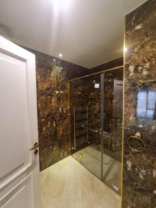 La salle de bains est pourvue d'une douche avec une porte en verre. dans l'établissement شقة فخمة باطلالة جذابة, à Irbid