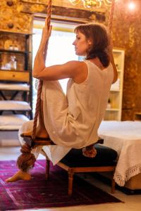 a woman sitting on a swing in a room at Trieste Neve Tzedek Boutique Suites Tel Aviv in Tel Aviv