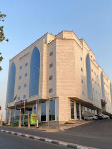 ARAEK AL KHLOOD HOTEL في مكة المكرمة: مبنى كبير فيه باص واقف امامه