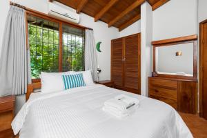 a bedroom with a large white bed and a window at Hotel Boutique Bahia Esmeralda in Potrero +121 photos