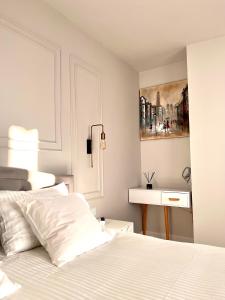 a bedroom with a white bed and a painting on the wall at Ghinda Nest in Bistriţa