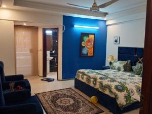 a bedroom with a bed and a blue wall at Parkway Apartments in Rawalpindi