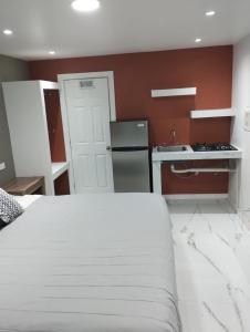um quarto com uma cama branca e uma cozinha em HABITACION SENCILLA CAMA KS Y BAÑO em Ciudad Juárez